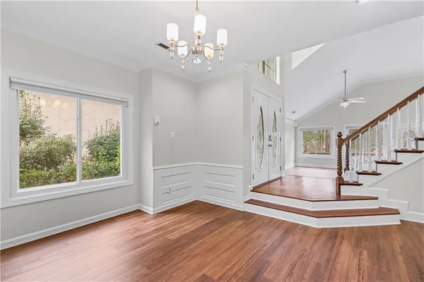 a view of front door with hallway and wooden floor