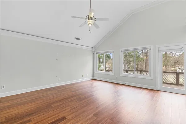 a view of an empty room with a window and wooden floor