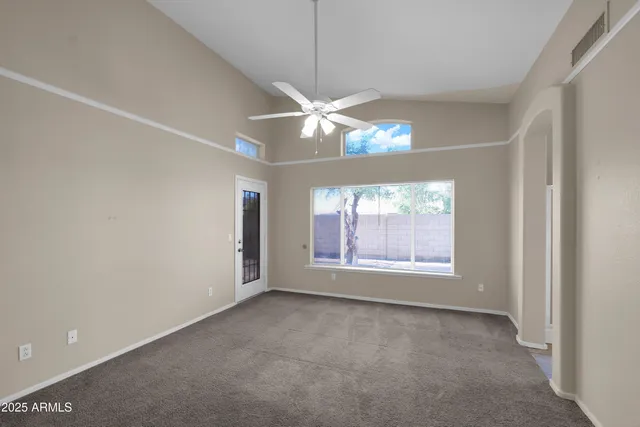 an empty room with a window and a ceiling fan