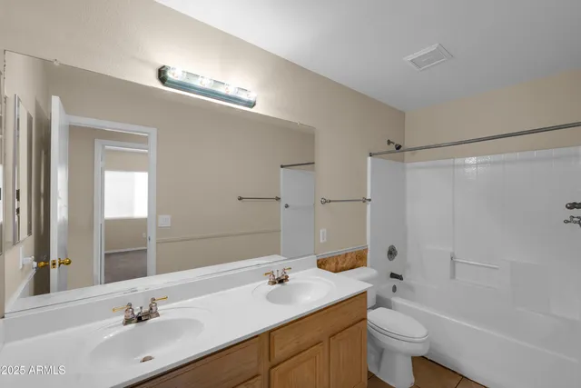 a bathroom with a bathtub shower sink vanity mirror and toilet