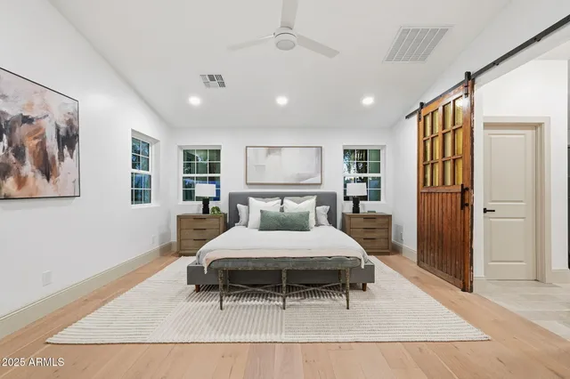 a spacious bedroom with a large bed and a chandelier