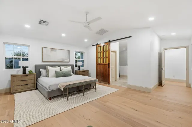 a bedroom with a large bed and a flat tv screen