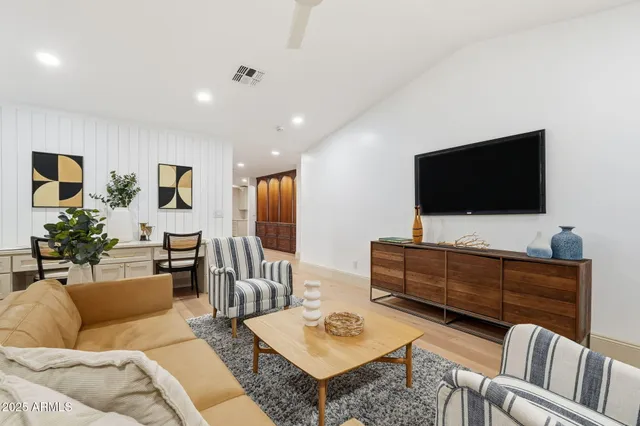 a living room with furniture a rug and a table