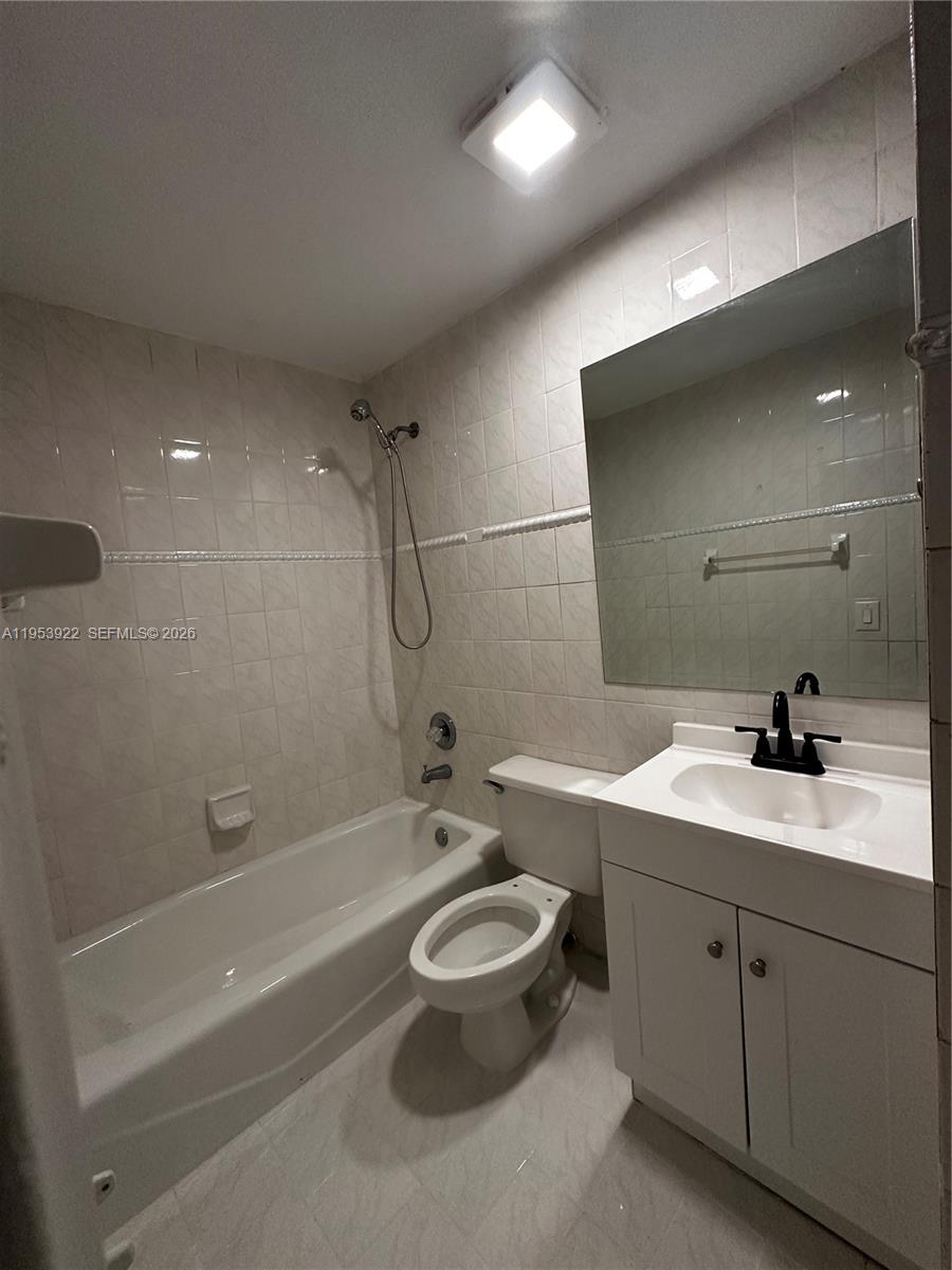 350 West 34th Street Hialeah, FL 33012 - Photo 4 of 22 a bathroom with a toilet a sink a mirror and bathtub