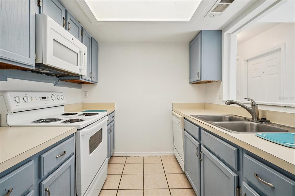 5606 Southwest 8th Place Gainesville, FL 32607 - Photo 8 of 28 a kitchen with a sink stove top oven and cabinets