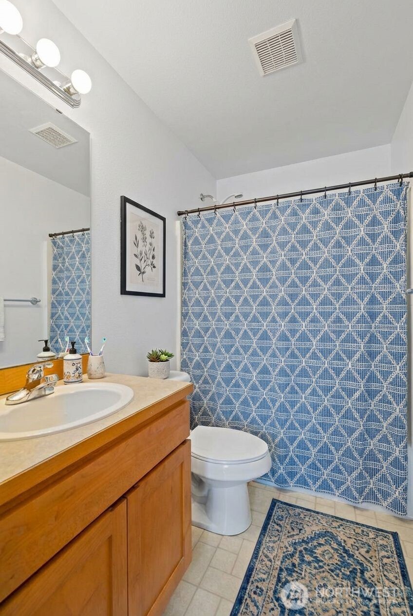 1496 Aberdeen Avenue Northeast Renton, WA 98056 - Photo 25 of 28 a bathroom with a toilet a sink and a shower curtain