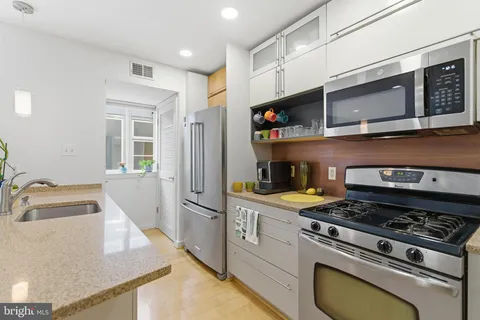 a kitchen with stainless steel appliances granite countertop a stove and a sink