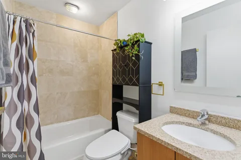 a bathroom with a granite countertop sink toilet and shower