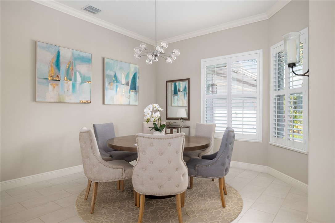 933 Yearling Trail Sebastian, FL 32958 - Photo 16 of 36 a dining room with furniture a large window and wooden floor