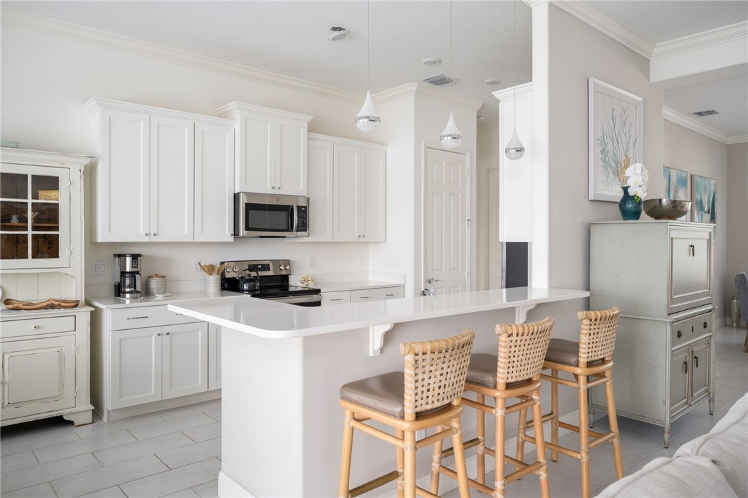 933 Yearling Trail Sebastian, FL 32958 - Photo 19 of 36 a kitchen with white cabinets and stainless steel appliances