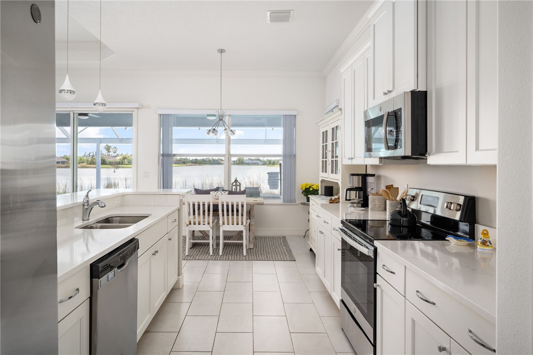 933 Yearling Trail Sebastian, FL 32958 - Photo 21 of 36 a kitchen with stainless steel appliances granite countertop a stove a sink and white cabinets