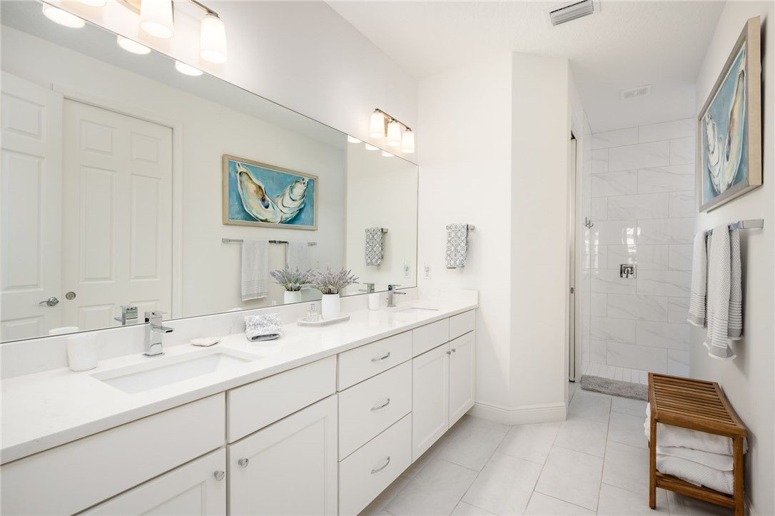 933 Yearling Trail Sebastian, FL 32958 - Photo 27 of 36 a en suite bathroom with a double vanity sink a mirror and a shower