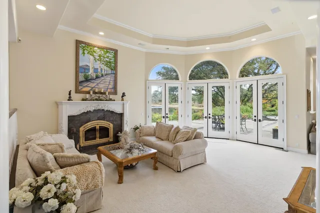 a living room with furniture a large window and dining table