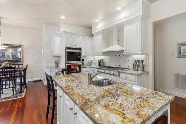 a spacious bathroom with a double vanity sink a mirror a bathtub and window