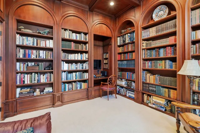 a view of a dining room with furniture a chandelier and a window