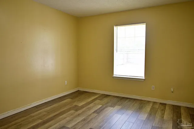 a view of a room with wooden floor and a window