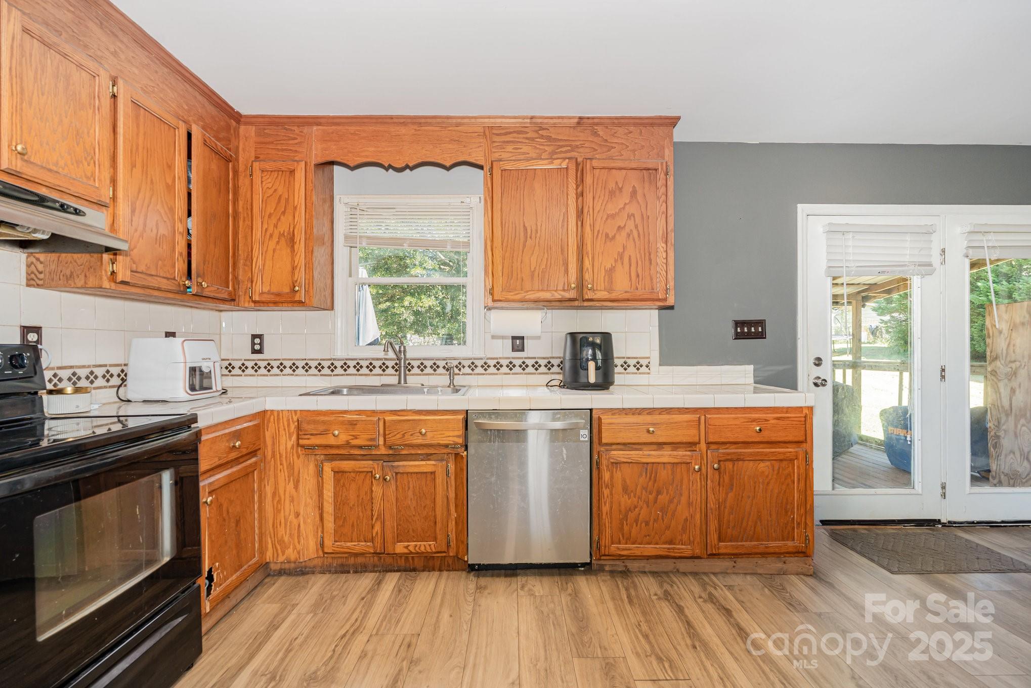 716 McDaniel Road Kings Mountain, NC 28086 - Photo 14 of 35 a large kitchen with stainless steel appliances granite countertop a stove a sink dishwasher and a microwave oven with wooden floor