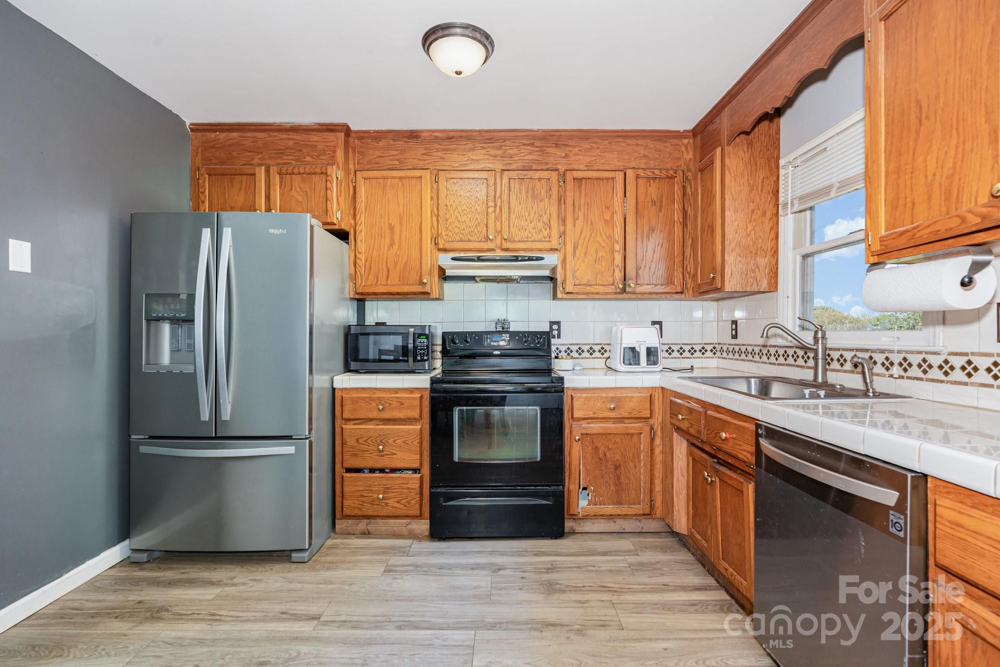 716 McDaniel Road Kings Mountain, NC 28086 - Photo 15 of 35 a kitchen with granite countertop stainless steel appliances and wooden cabinets