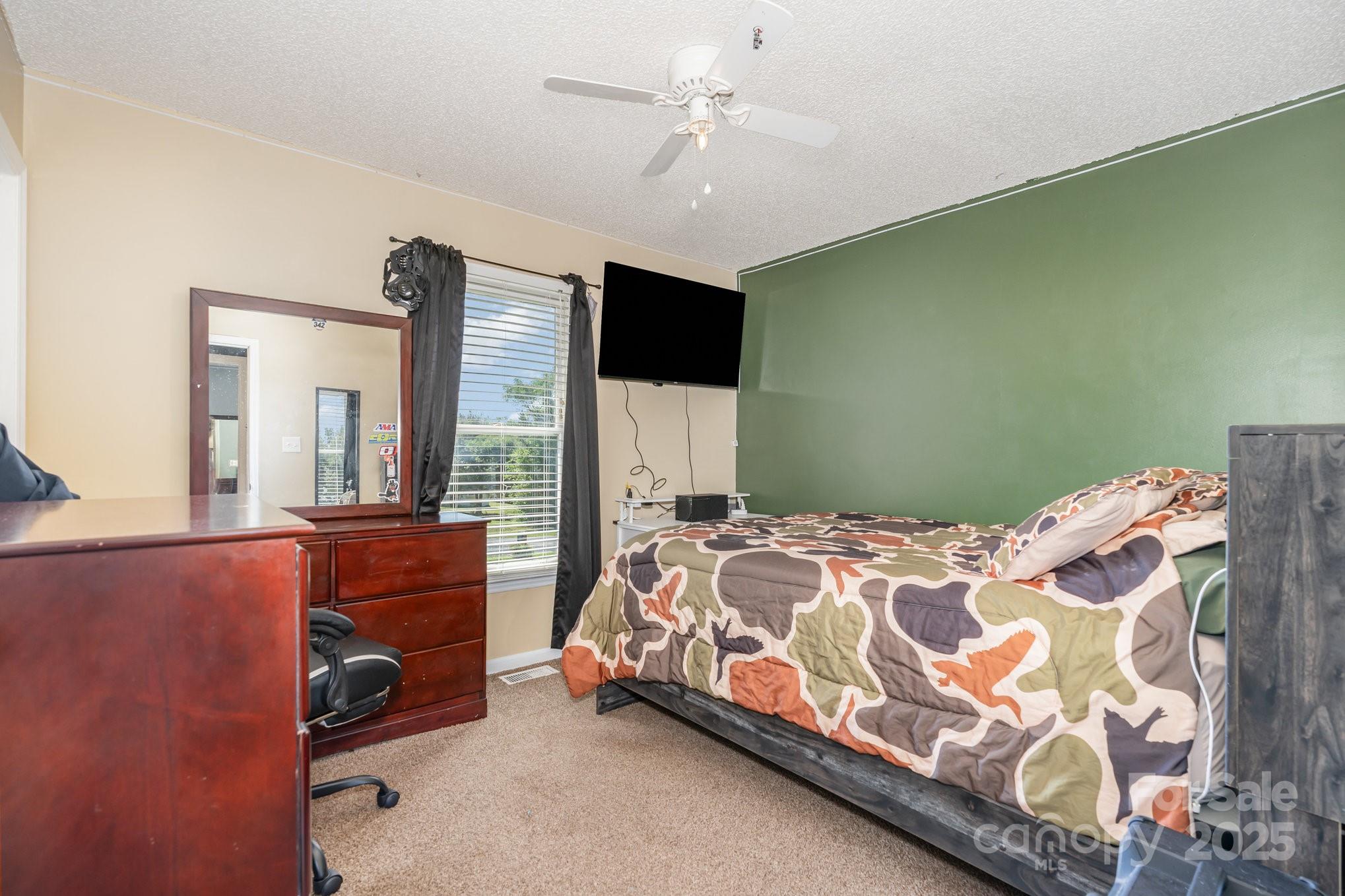 716 McDaniel Road Kings Mountain, NC 28086 - Photo 22 of 35 a bedroom with a bed and a flat tv screen on dresser