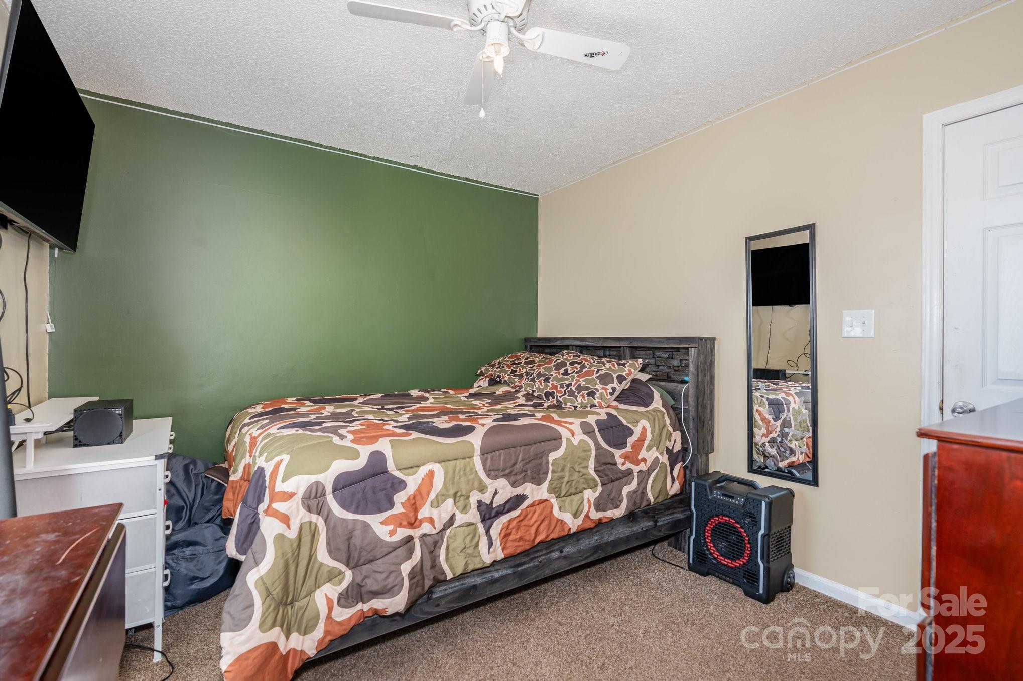 716 McDaniel Road Kings Mountain, NC 28086 - Photo 24 of 35 a bedroom with a bed and a flat tv screen
