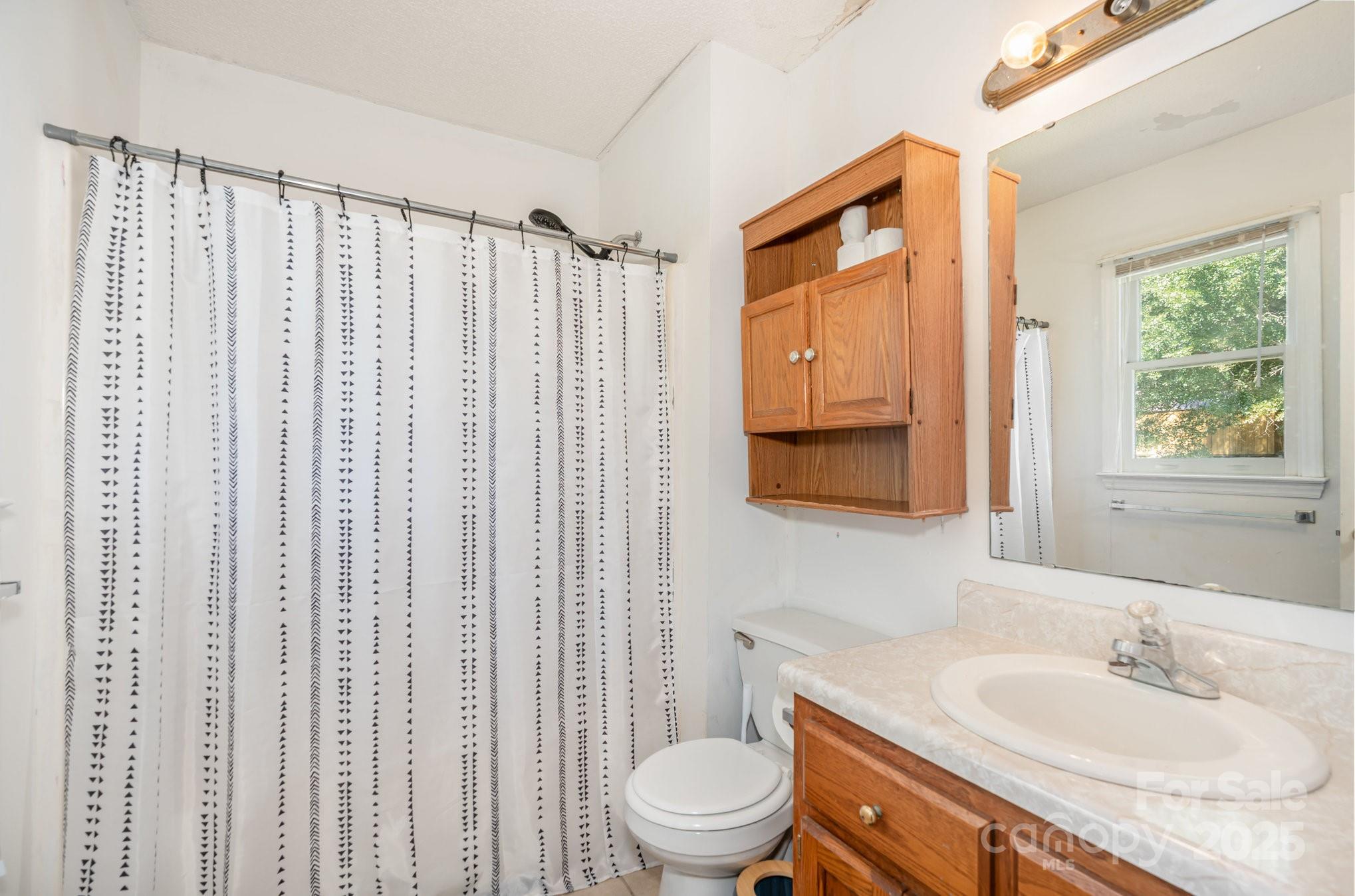716 McDaniel Road Kings Mountain, NC 28086 - Photo 29 of 35 a bathroom with a granite countertop sink toilet and mirror