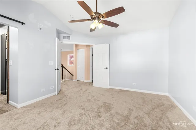 an empty room with closet and a ceiling fan