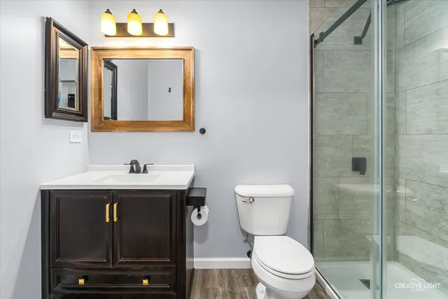 a bathroom with a toilet sink vanity and mirror