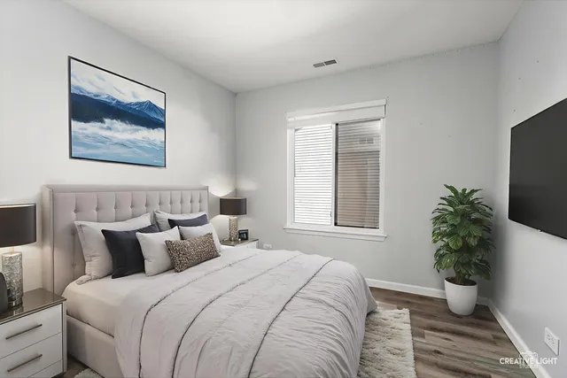 a bedroom with bed plant and a window