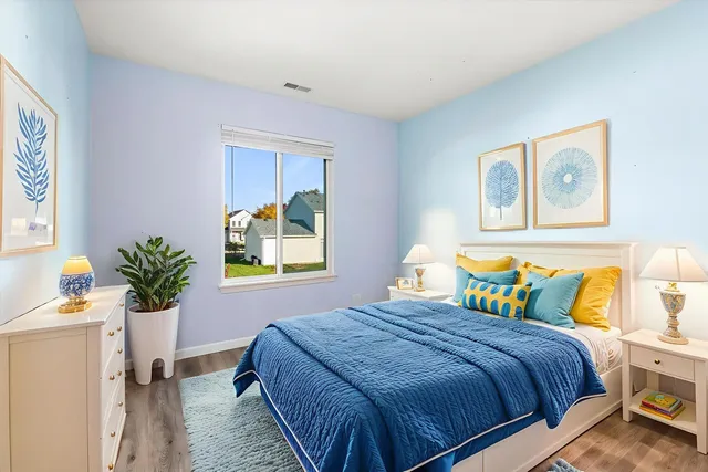 a bedroom with bed and paintings on the wall