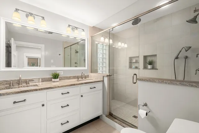 a bathroom with a double vanity sink mirror double and shower