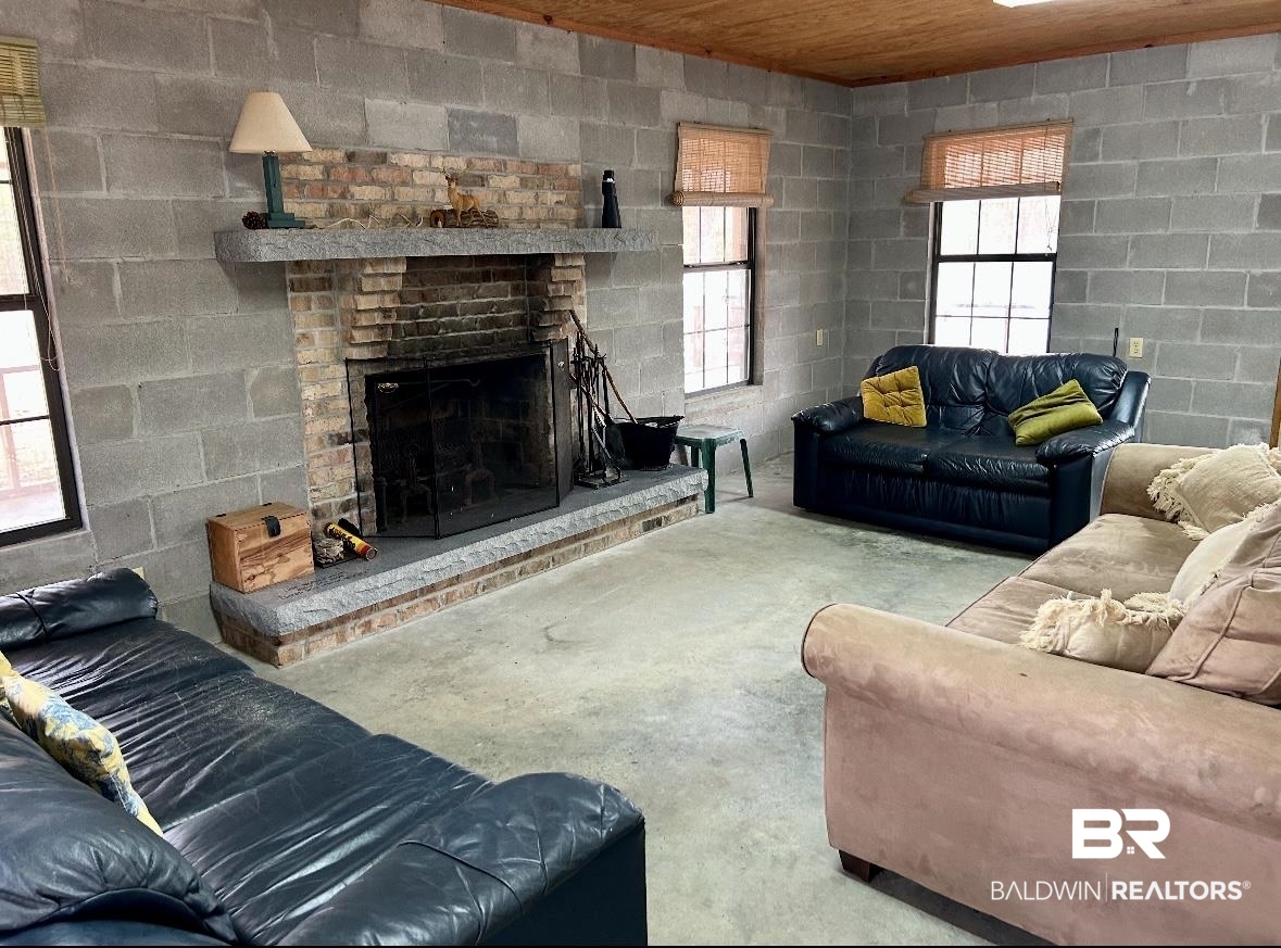 3881 Old Atmore Road Flomaton, AL 36441 - Photo 9 of 22 Living room with concrete floors, wood ceiling, and a fireplace
