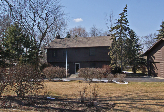 23740 North High Ridge Drive Lake Zurich, IL 60047 - Photo 1 of 17 a front view of a house with a yard covered in snow