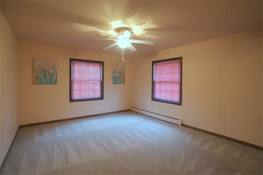 23740 North High Ridge Drive Lake Zurich, IL 60047 - Photo 13 of 17 an empty room with windows and chandelier fan