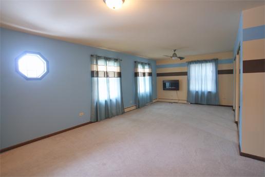 23740 North High Ridge Drive Lake Zurich, IL 60047 - Photo 10 of 17 an empty room with a fireplace and windows