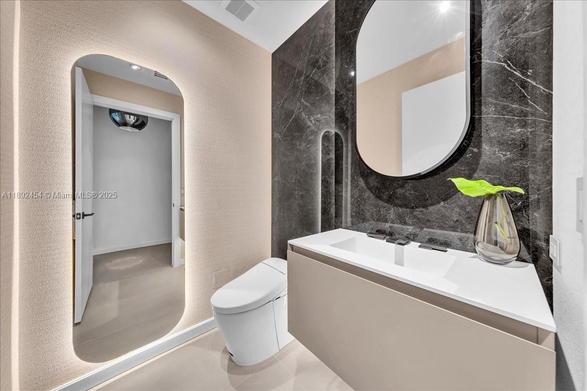 888 Biscayne Boulevard, Unit PH5704 Miami, FL 33132 - Photo 11 of 62 a bathroom with a sink mirror and toilet