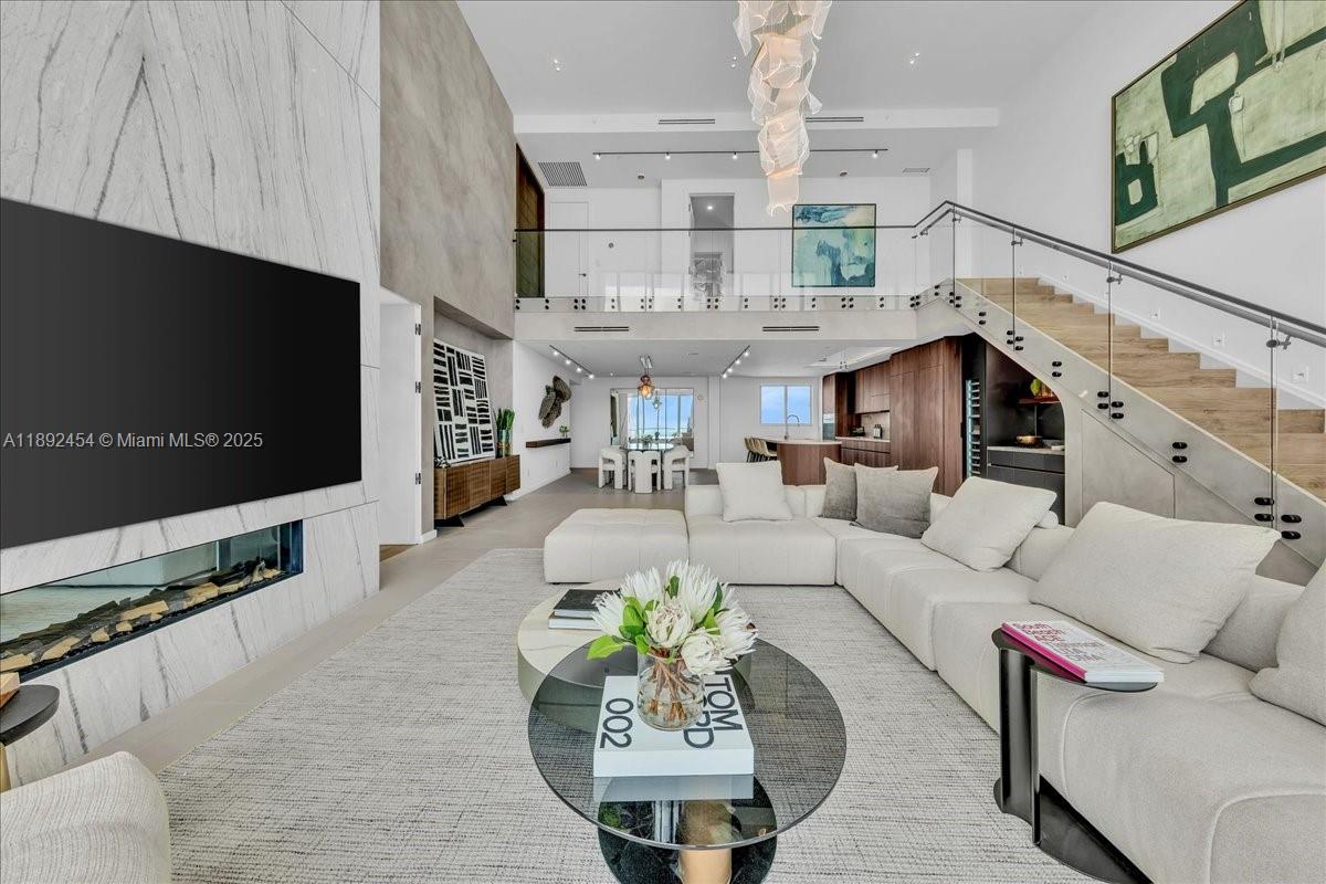 888 Biscayne Boulevard, Unit PH5704 Miami, FL 33132 - Photo 22 of 62 a living room with furniture a flat screen tv and kitchen view