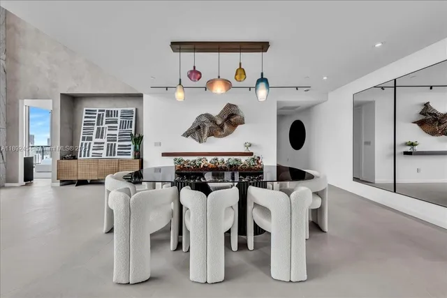 a living room with furniture a plant and a large window