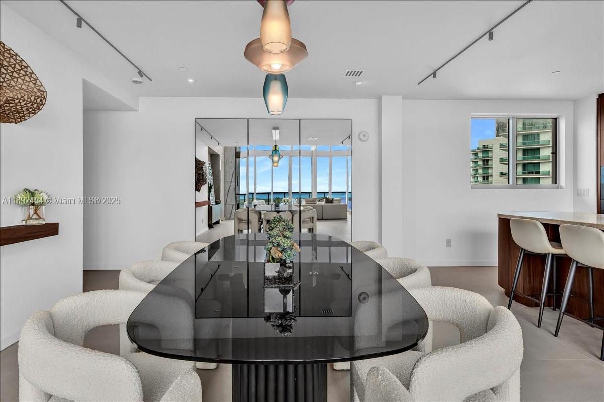 888 Biscayne Boulevard, Unit PH5704 Miami, FL 33132 - Photo 26 of 62 a dining room with furniture and a chandelier