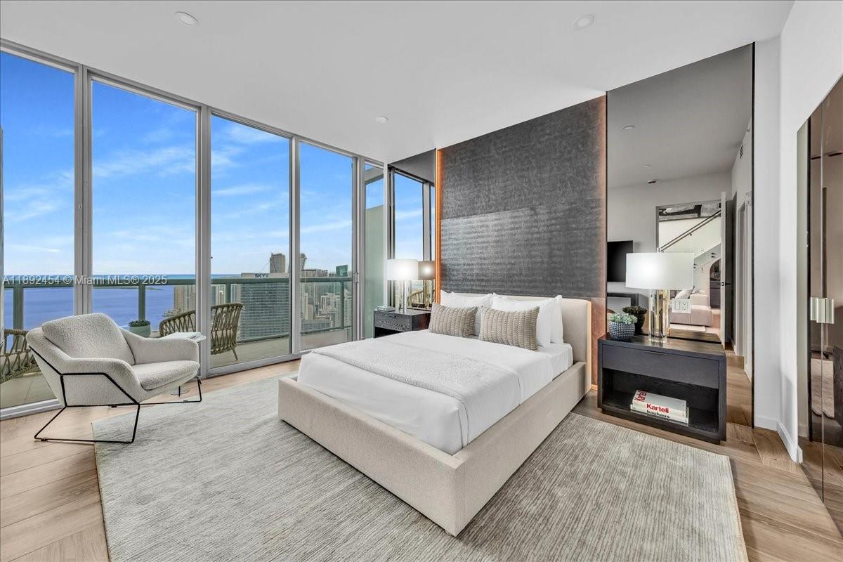 888 Biscayne Boulevard, Unit PH5704 Miami, FL 33132 - Photo 28 of 62 a bedroom with a large bed and a night stand