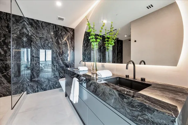 a bedroom with a large bed and a large mirror