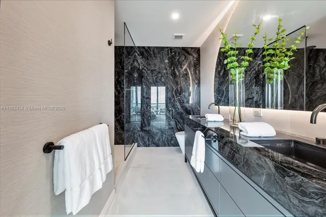 a bathroom with a granite countertop sink toilet and shower