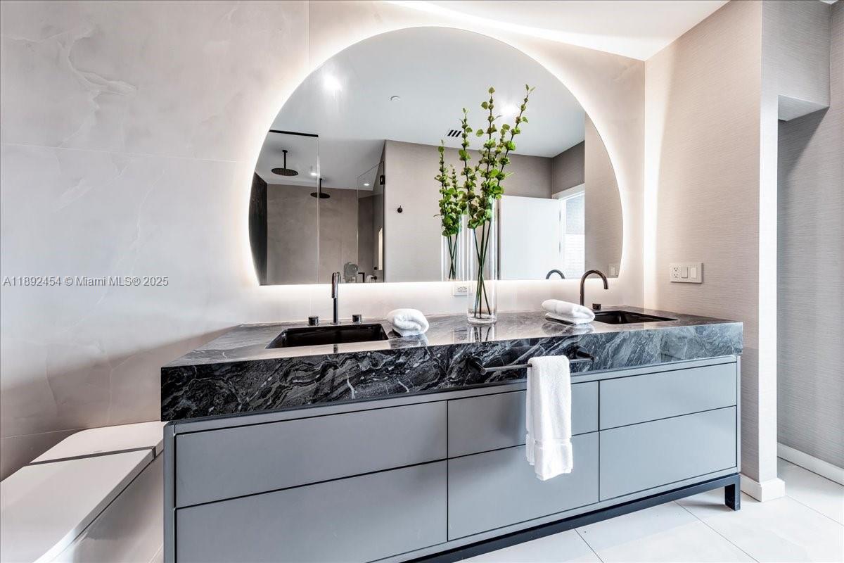 888 Biscayne Boulevard, Unit PH5704 Miami, FL 33132 - Photo 33 of 62 a bathroom with a granite countertop sink and a mirror