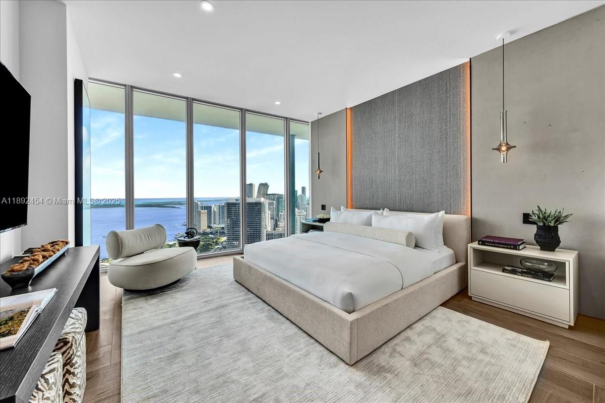888 Biscayne Boulevard, Unit PH5704 Miami, FL 33132 - Photo 43 of 62 a spacious bedroom with a bed and glass window