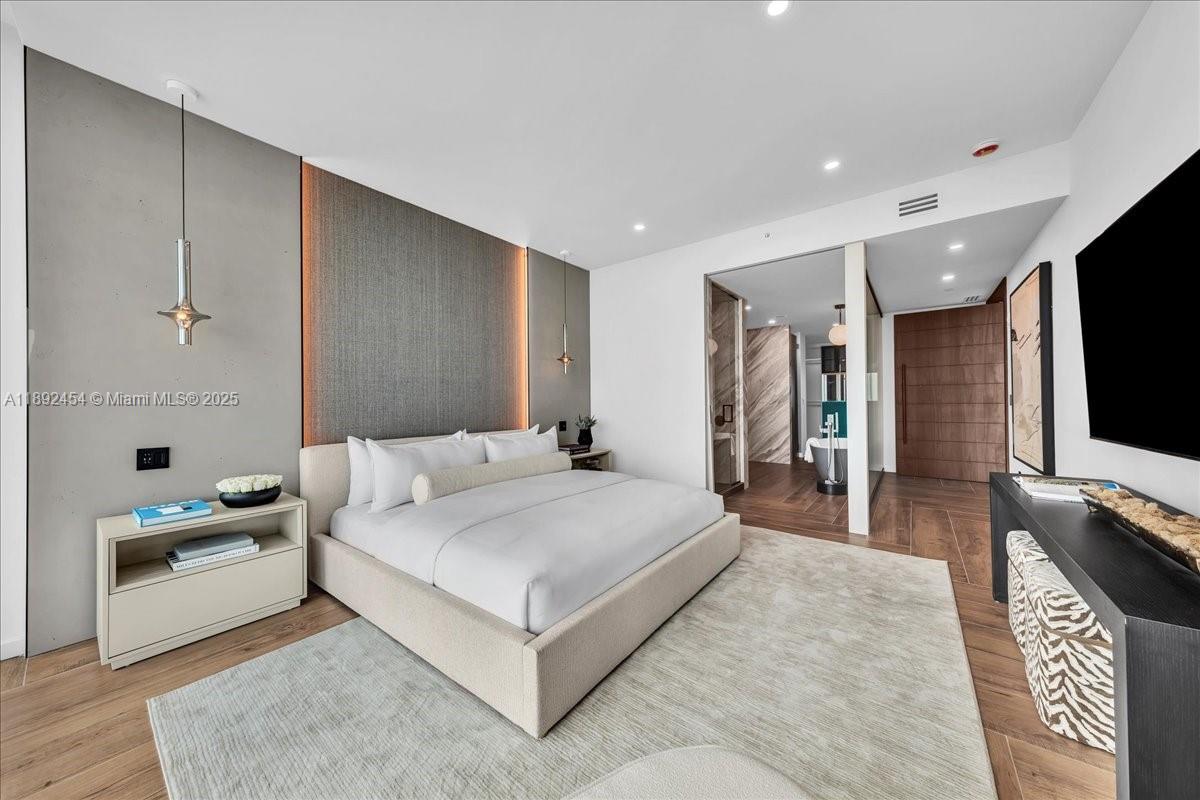 888 Biscayne Boulevard, Unit PH5704 Miami, FL 33132 - Photo 47 of 62 a spacious bedroom with a bed and a flat screen tv