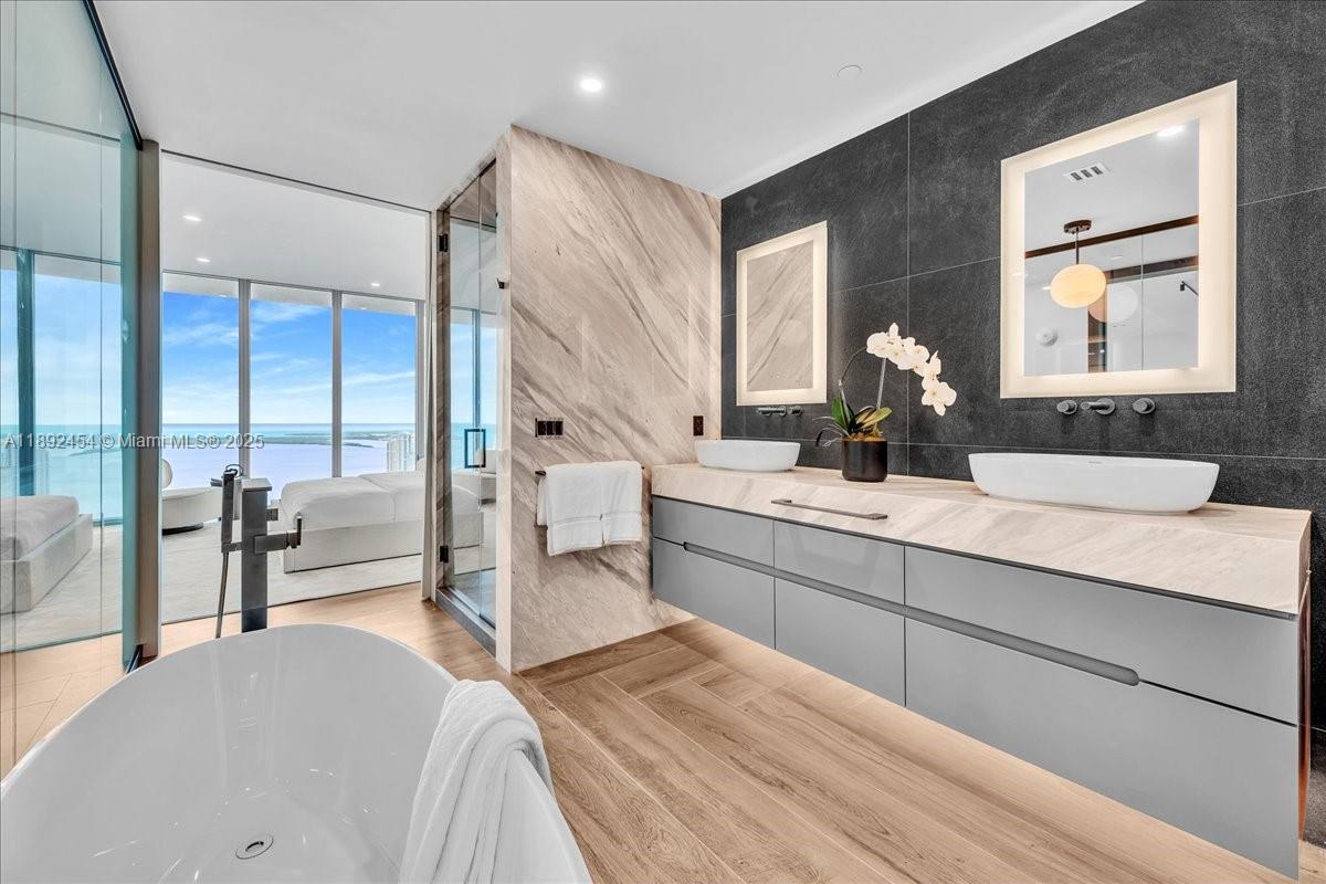 888 Biscayne Boulevard, Unit PH5704 Miami, FL 33132 - Photo 56 of 62 a bathroom with a double vanity sink and mirror