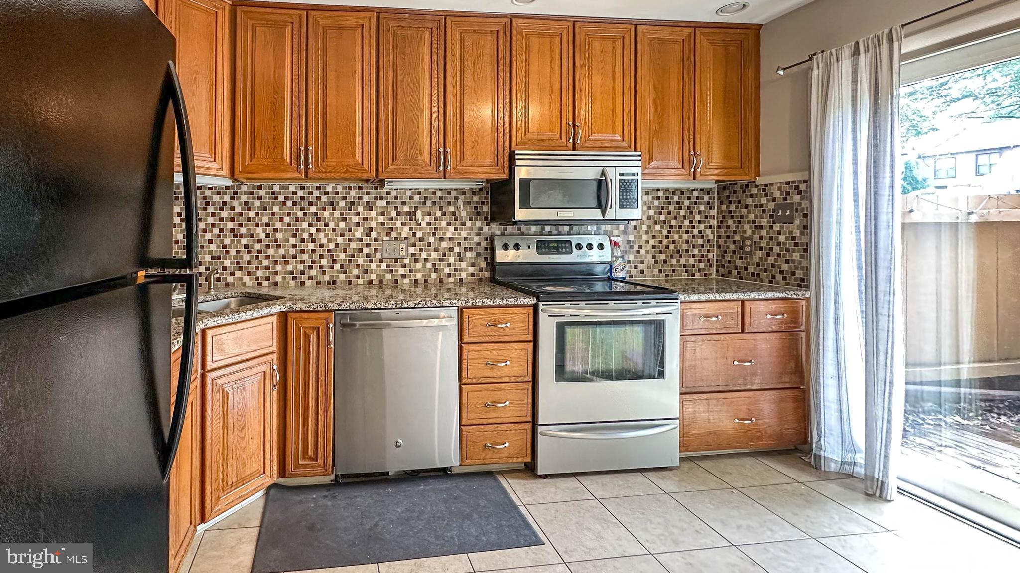 7 Pinehurst Court Reading, PA 19607 - Photo 2 of 11 a kitchen with stainless steel appliances wooden cabinets and a stove top oven