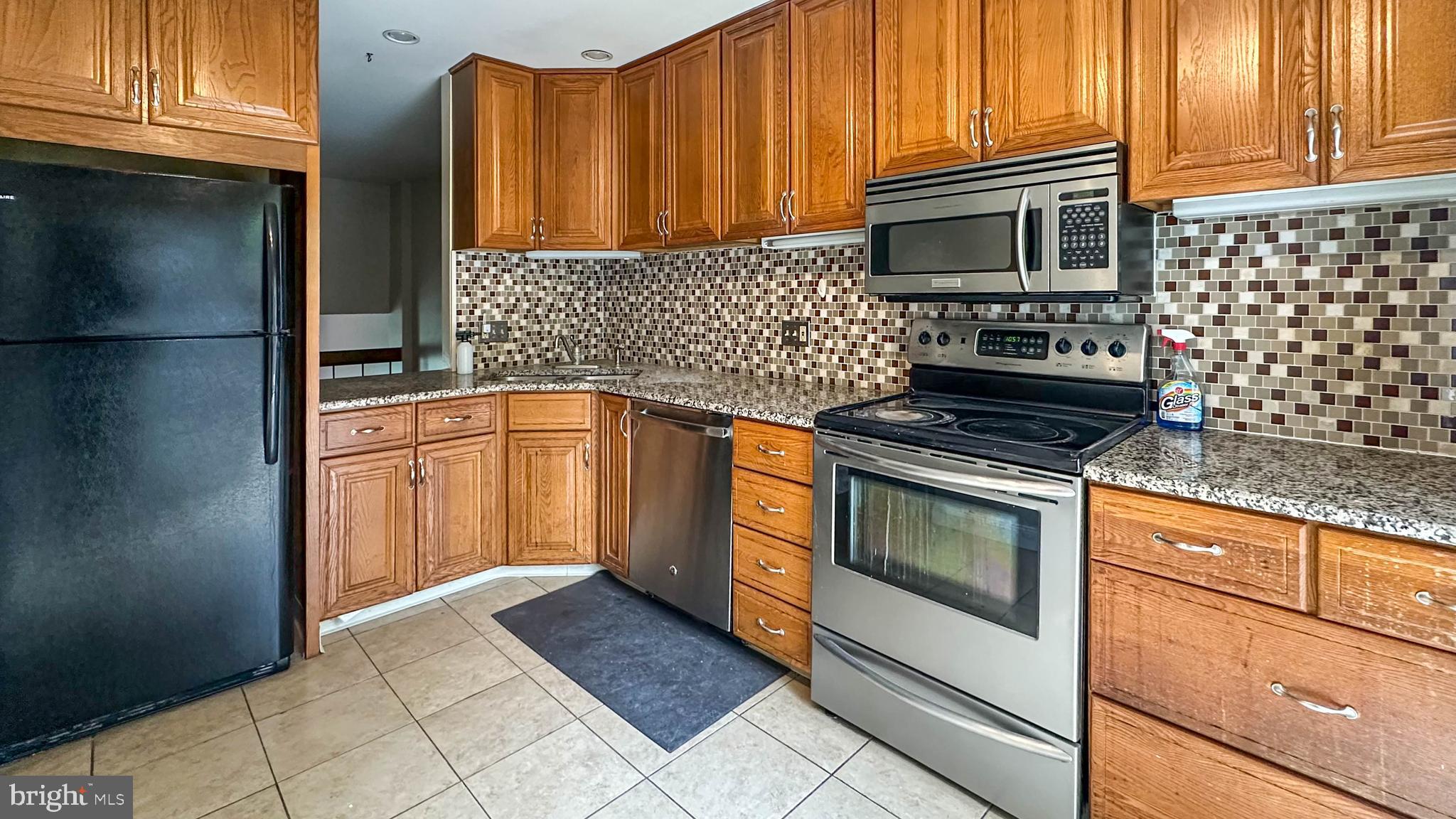 7 Pinehurst Court Reading, PA 19607 - Photo 3 of 11 a kitchen with granite countertop a stove top oven microwave and cabinets
