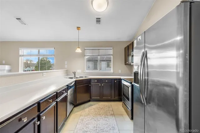 a kitchen with stainless steel appliances granite countertop a sink and a refrigerator