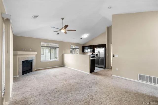 a view of an empty room with a fireplace and a window