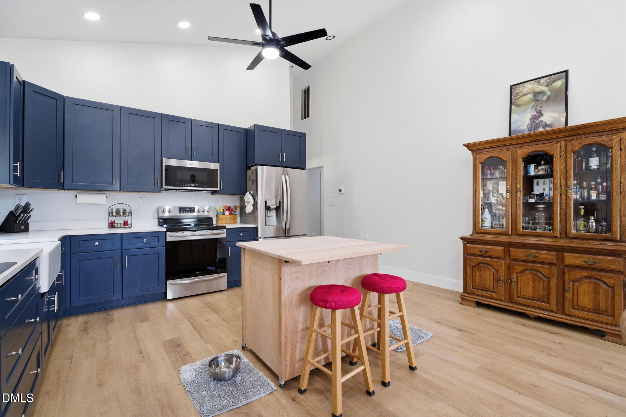 5416 Pulley Town Road Zebulon, NC 27597 - Photo 56 of 74 a kitchen with a refrigerator a stove top oven a dining table and chairs with wooden floor